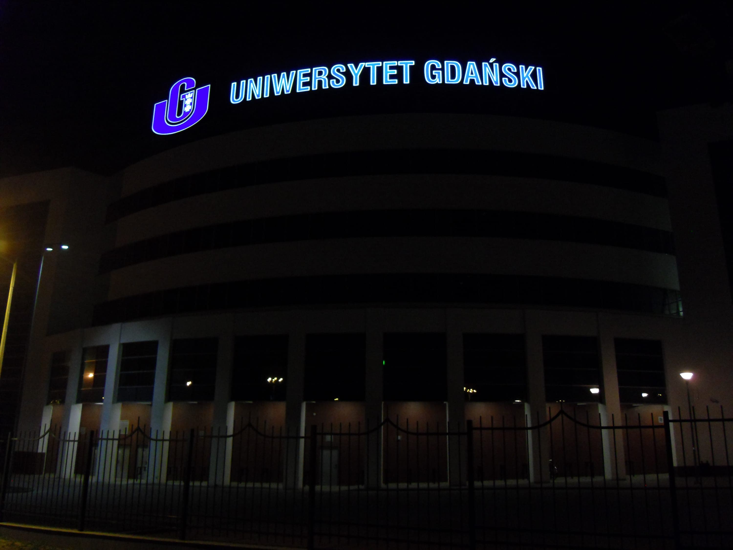 Gdańsk Üniversitesi binası gece, dış aydınlatma ile aydınlatılmış.